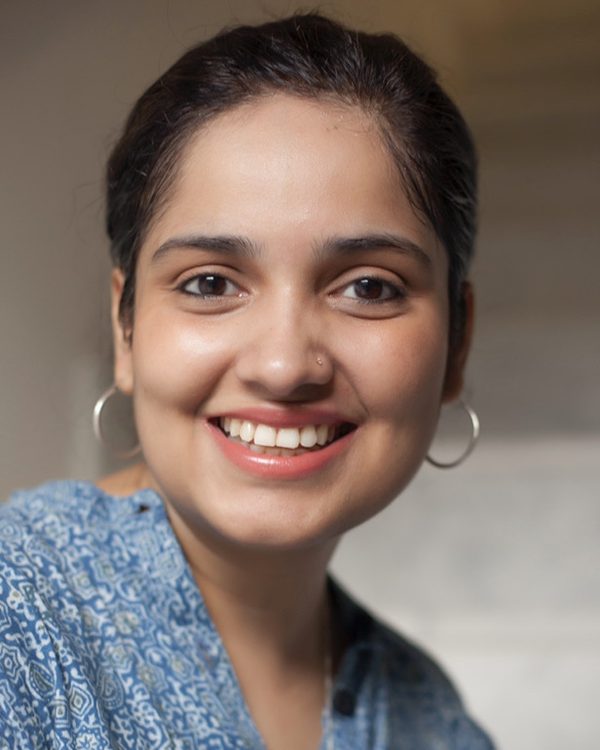 Hareem Sumbul, smiling, in a blue patterned top